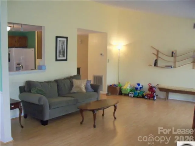 an empty room with wooden floor fireplace and windows