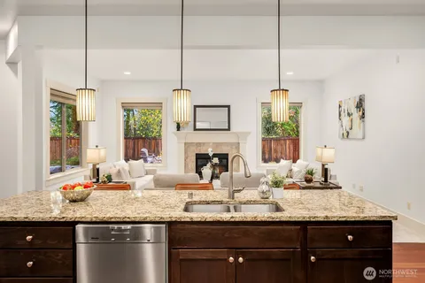 a kitchen with granite countertop a sink a counter space appliances and cabinets