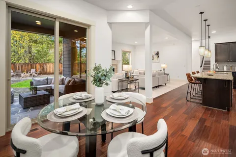 a dining room with furniture a large window and wooden floor