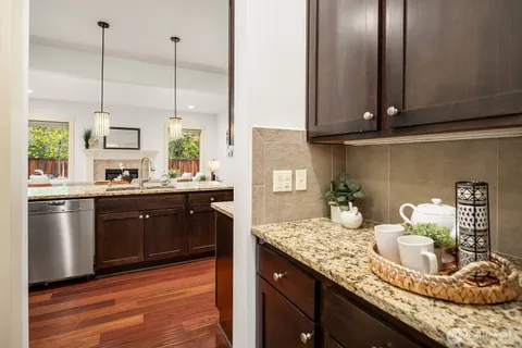 a kitchen with kitchen island granite countertop wooden cabinets and a wooden floor