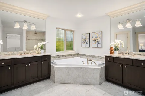 a spacious bathroom with a tub a double vanity sink and mirror