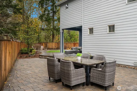 a view of a patio with a table and chairs next to a yard