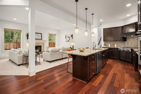 a kitchen with stainless steel appliances granite countertop a sink counter space and living room view