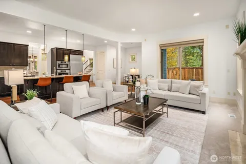 a living room with furniture kitchen view and a large window