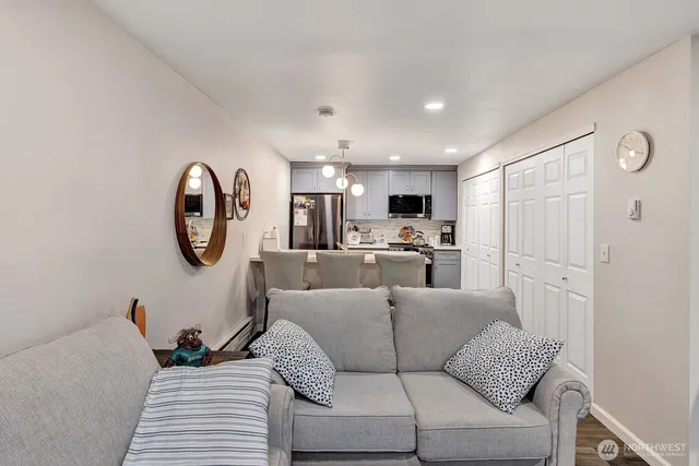 a living room with furniture a mirror and white walls