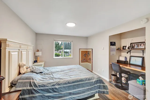 a bedroom with a bed and wooden floor