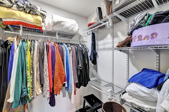 a view of walk in closet with clothes