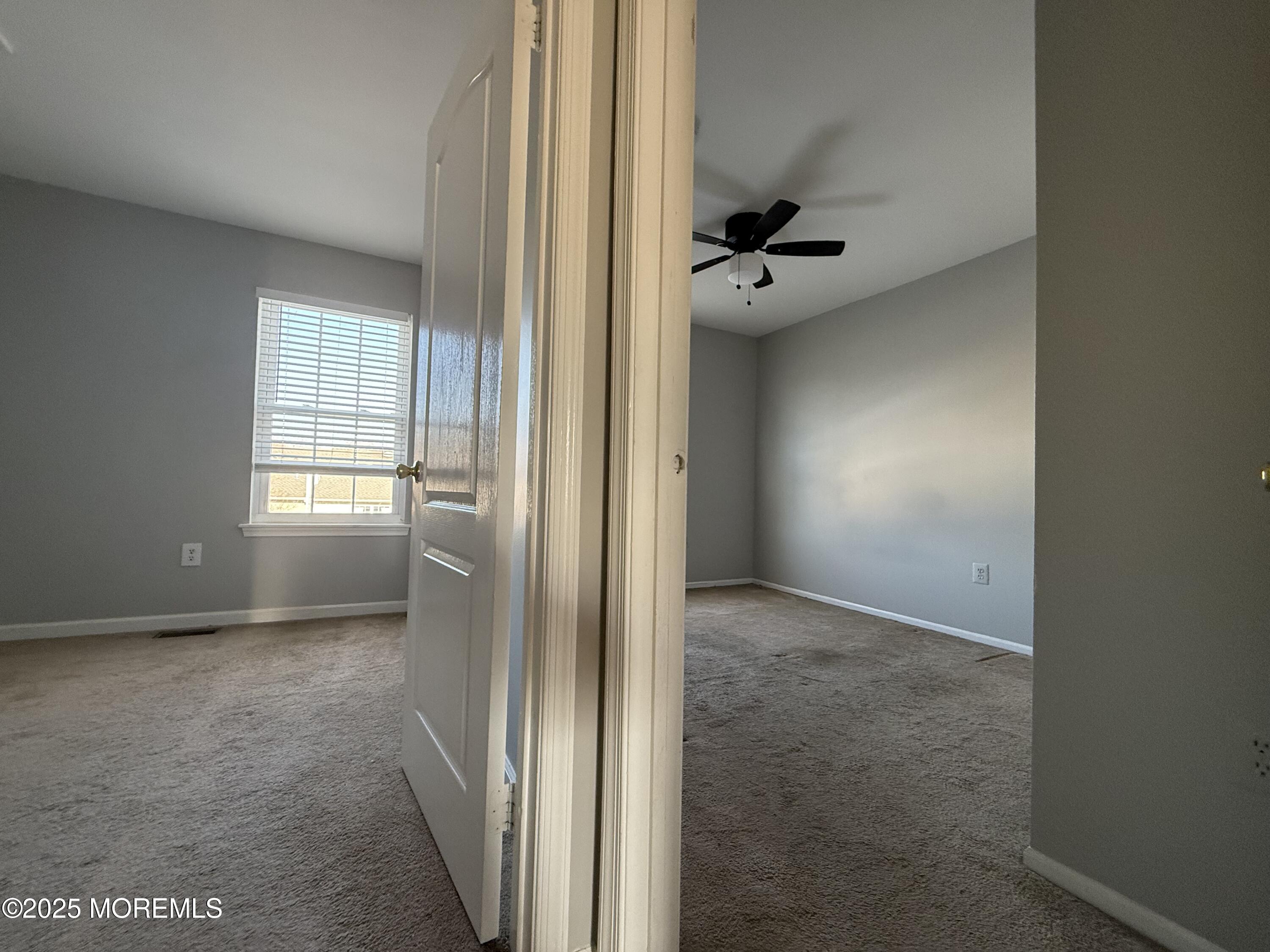 52 Aberdare Court, Unit 4 Freehold, NJ 07728 - Photo 14 of 18 an empty room with windows and a ceiling fan