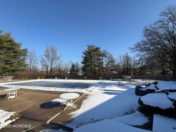 a view of a swimming pool with lawn chairs under an umbrella