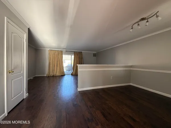 a view of a room with wooden floors and window