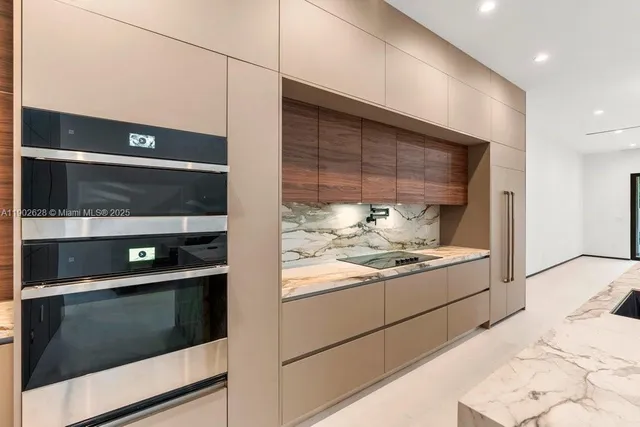 a large kitchen with stainless steel appliances kitchen island a large island in it