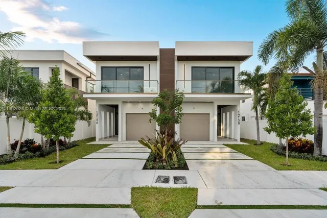 a view of house in front of a yard with potted plants
