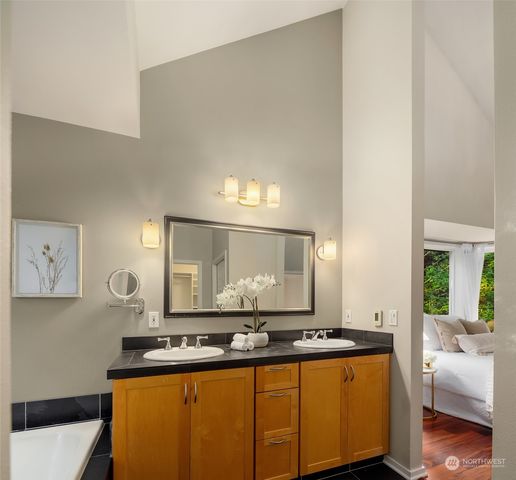 a large bathroom with a tub sink and mirror