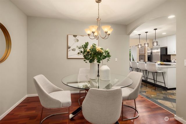 a dining room with furniture potted plants and wooden floor