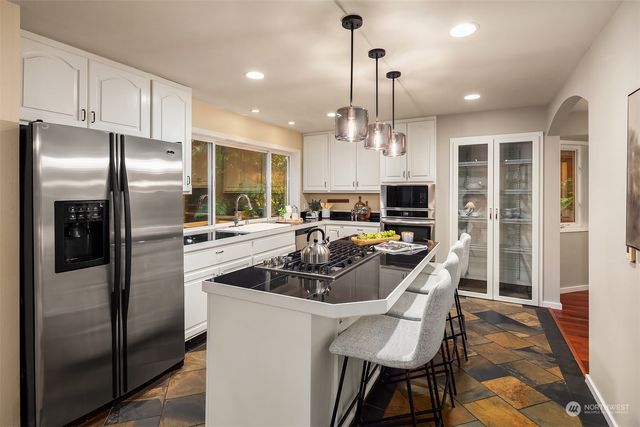 a kitchen with stainless steel appliances a refrigerator a stove a sink and a refrigerator