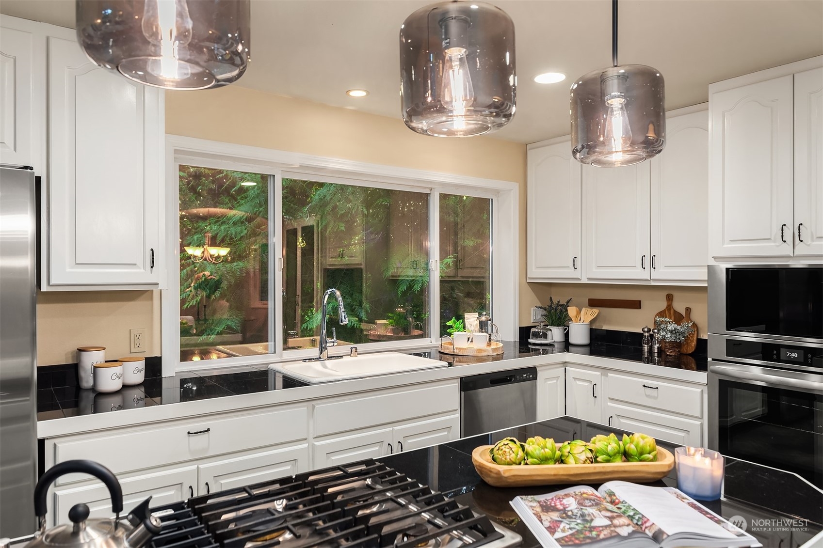 730 Redmond-Fall City Road Northeast Carnation, WA 98014 - Photo 28 of 40 a kitchen with a sink stainless steel appliances and chandelier