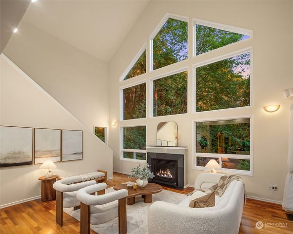 a living room with furniture a fireplace and a floor to ceiling window