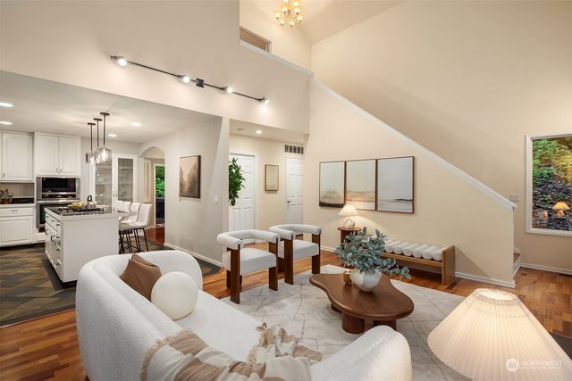 a living room with furniture kitchen view and a large window
