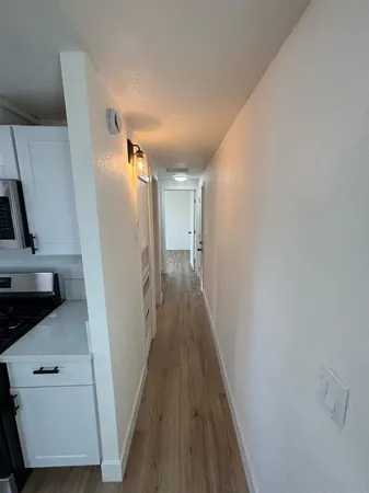 a view of a hallway with wooden floor and staircase