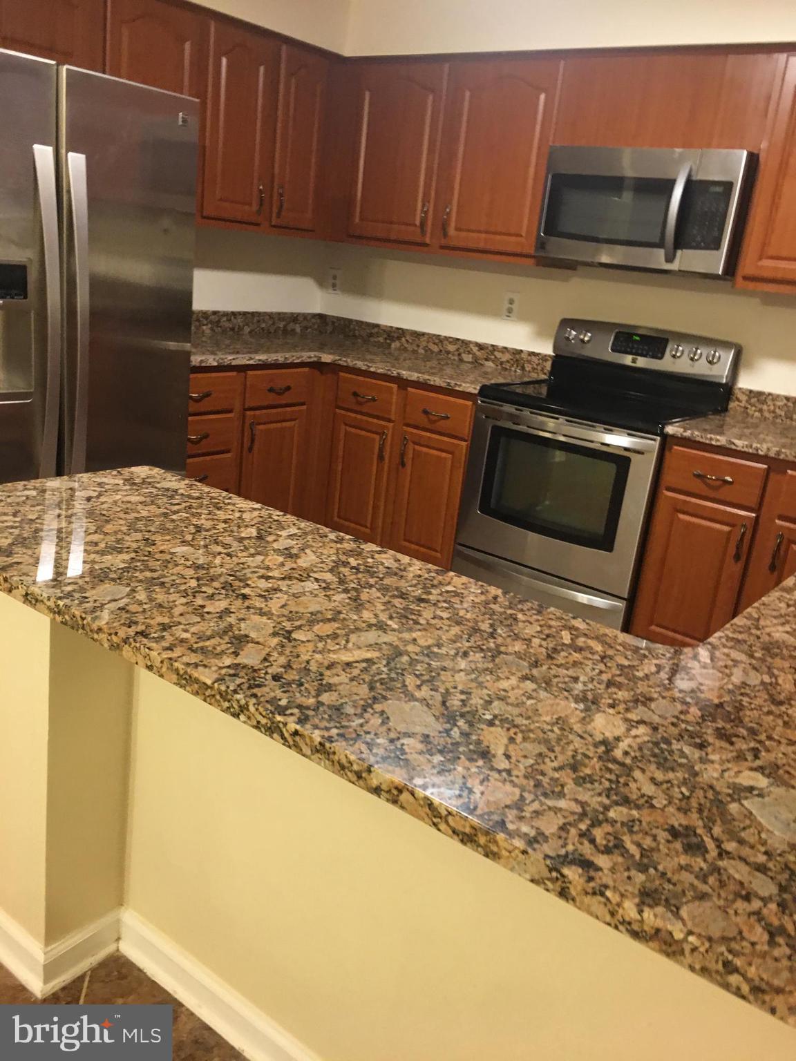 6159 Good Hunters Ride Columbia, MD 21045 - Photo 10 of 28 a kitchen with stainless steel appliances granite countertop a sink stove and refrigerator