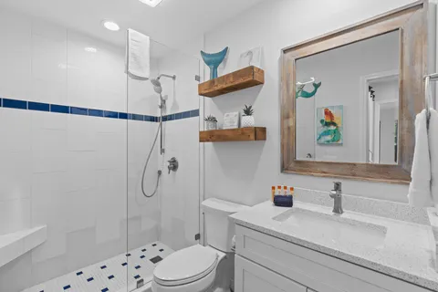 a bathroom with a sink a toilet and shower