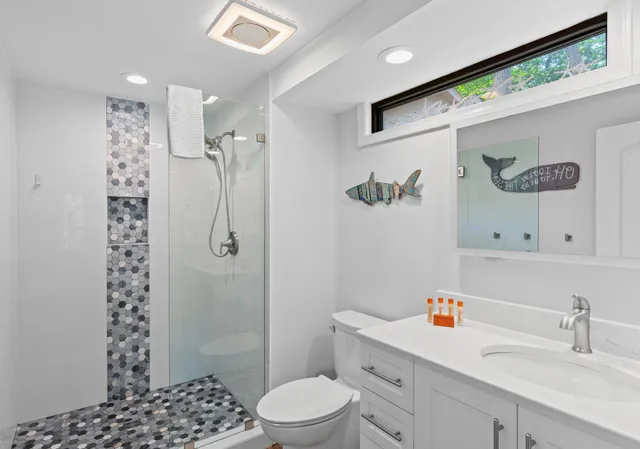 a bathroom with a sink a toilet and shower