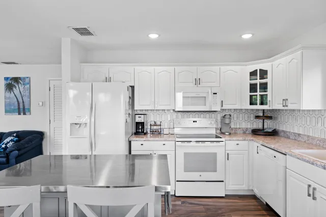 a kitchen with white cabinets and white appliances
