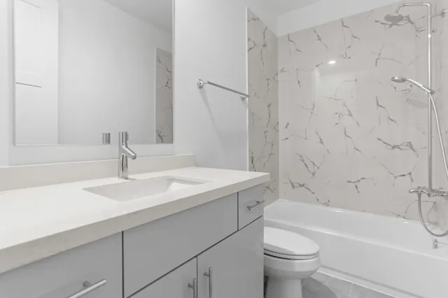 a bathroom with a sink toilet vanity and shower