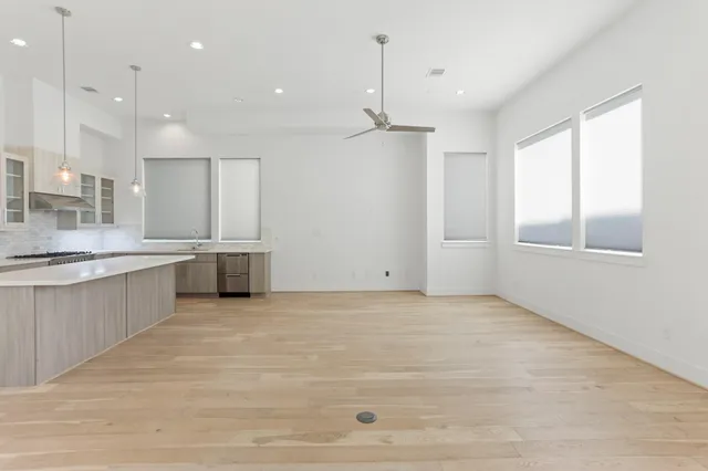 a view of an empty room with kitchen appliances and a window