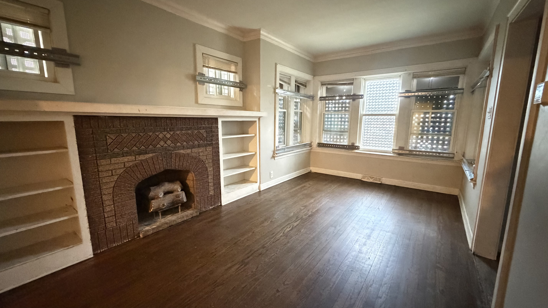 435 East 88th Place Chicago, IL 60619 - Photo 5 of 21 an empty room with wooden floor fireplace and windows