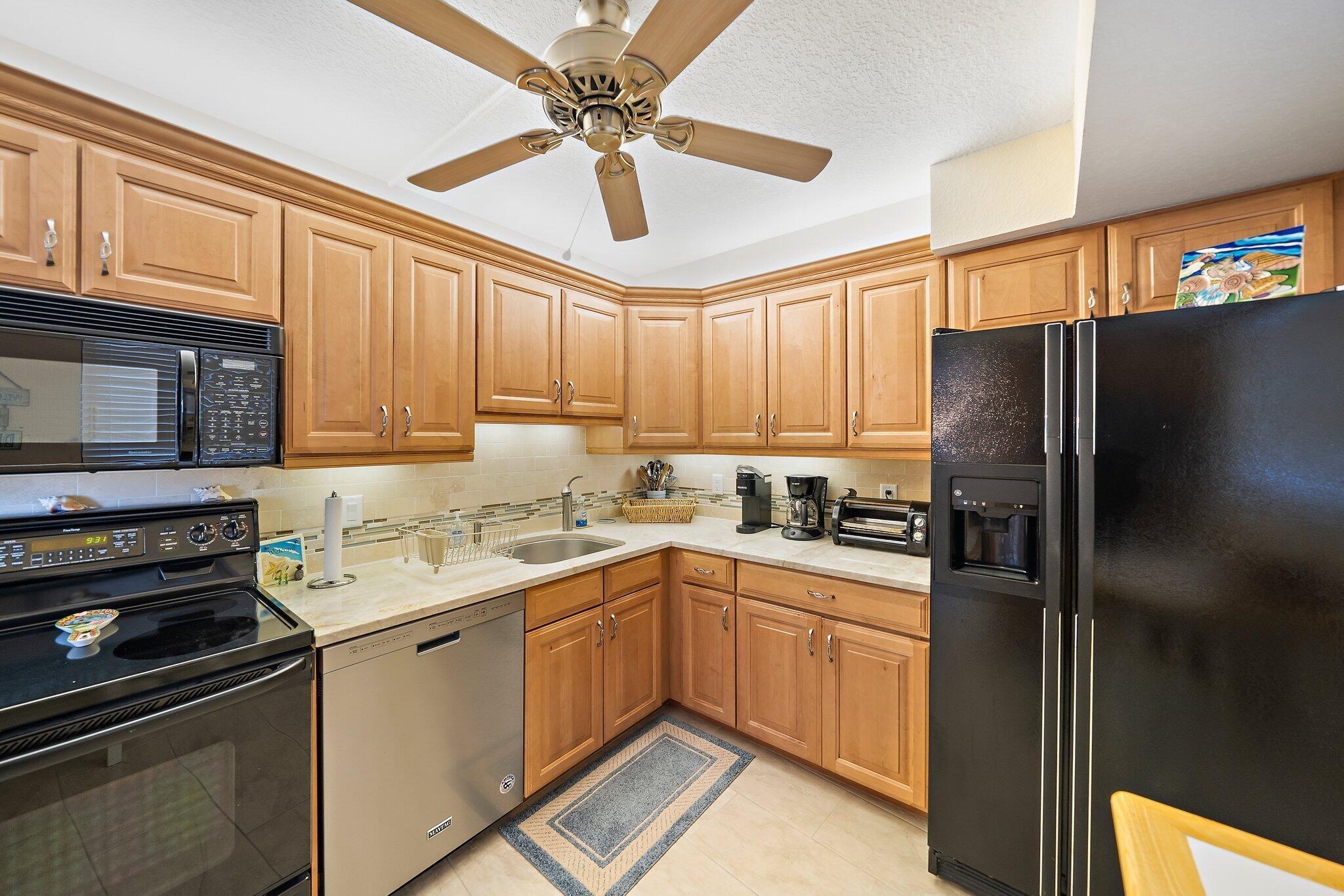 100 Ocean Trail Way, Unit 609 Jupiter, FL 33477 - Photo 14 of 66 a kitchen with a sink stainless steel appliances and cabinets
