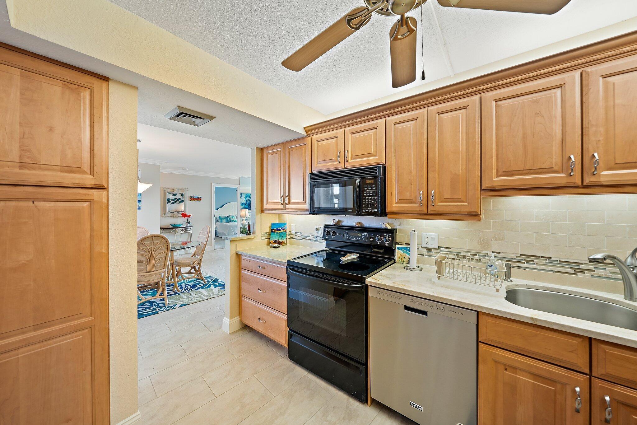 100 Ocean Trail Way, Unit 609 Jupiter, FL 33477 - Photo 15 of 66 a kitchen with stainless steel appliances granite countertop a refrigerator stove microwave and sink