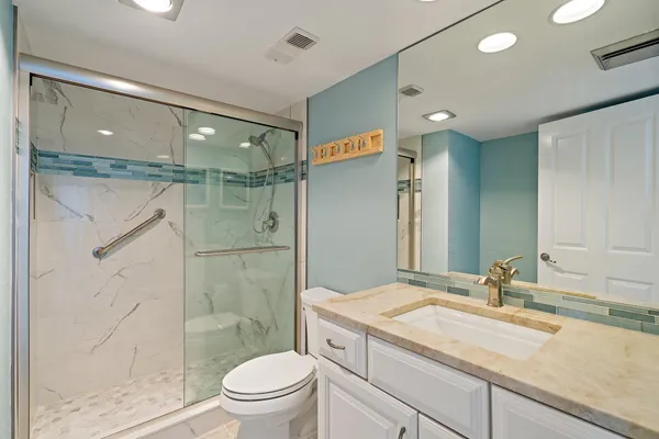 a bathroom with a toilet a sink and glass door