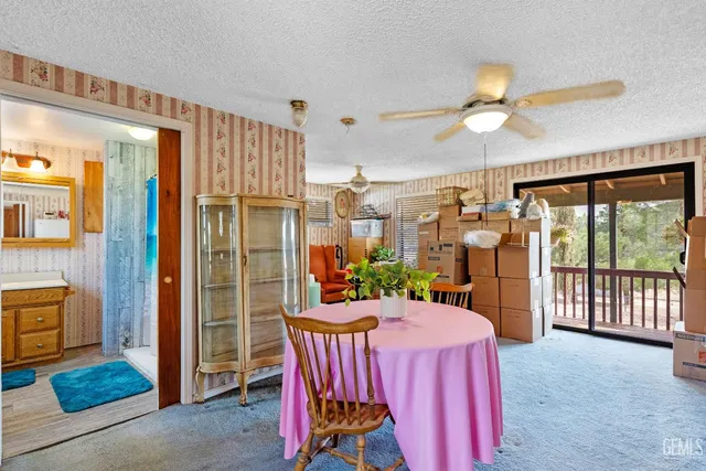 a dining room with furniture a chandelier and a large window