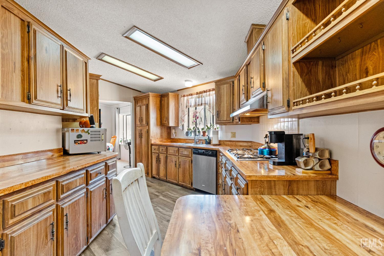Undisclosed Address Tehachapi, CA 93561 - Photo 8 of 32 a kitchen with stainless steel appliances granite countertop a stove a sink dishwasher and white cabinets with wooden floor