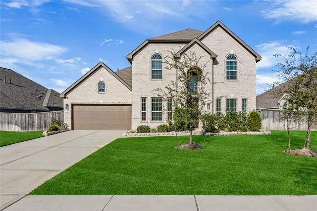 a front view of a house with a yard and trees