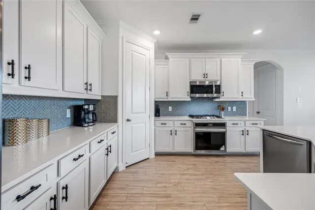 a kitchen with stainless steel appliances granite countertop a stove a sink and a refrigerator
