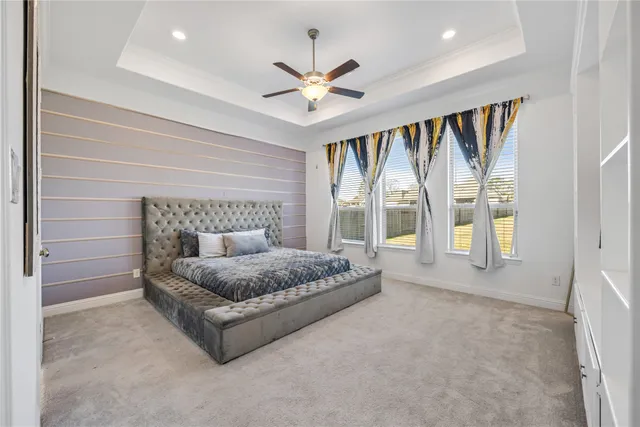 a spacious bedroom with a large bed and a chandelier