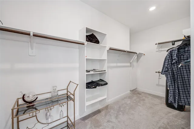 a view of walk in closet with clothes and shoes