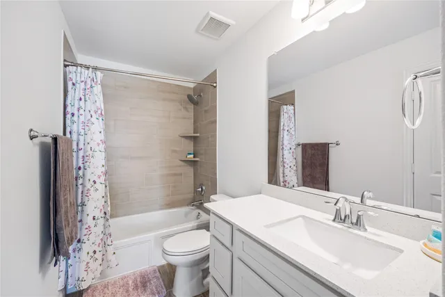 a bathroom with a sink a toilet a mirror a bathtub and shower