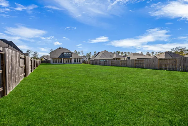 a view of a green field with house in the background