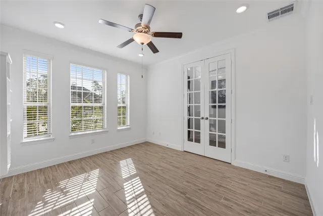 a view of an empty room with a window and wooden floor