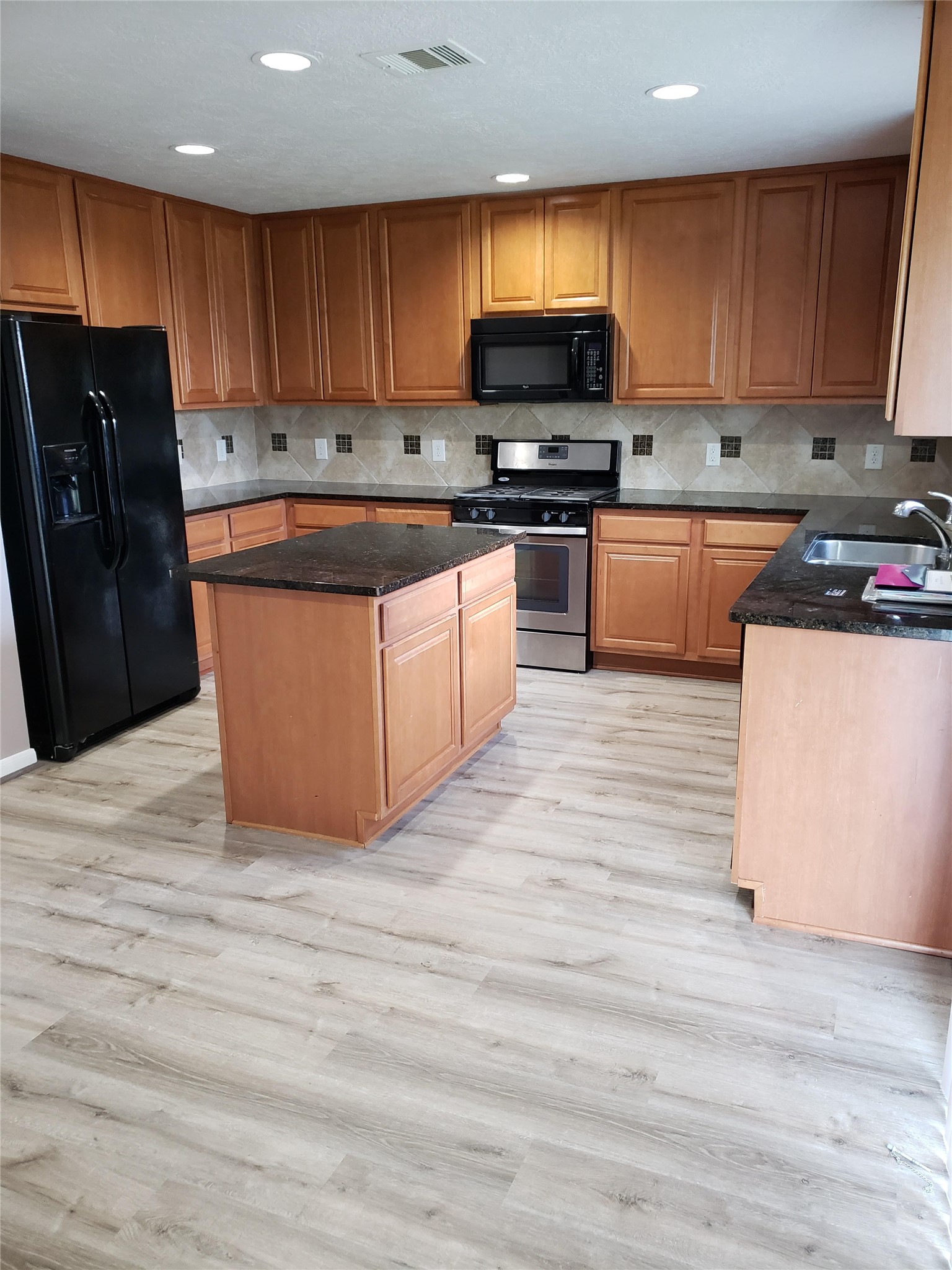 29314 Legends Bluff Drive Spring, TX 77386 - Photo 8 of 31 a kitchen with stainless steel appliances granite countertop a stove a sink dishwasher and a refrigerator with wooden floor