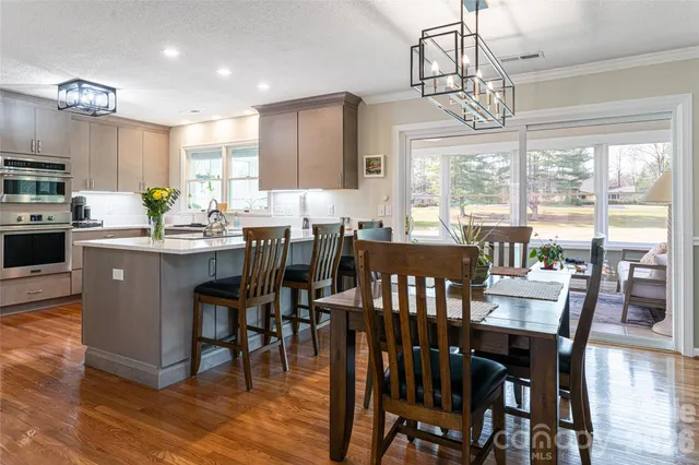 a view of a dining room with furniture a chandelier and wooden floor