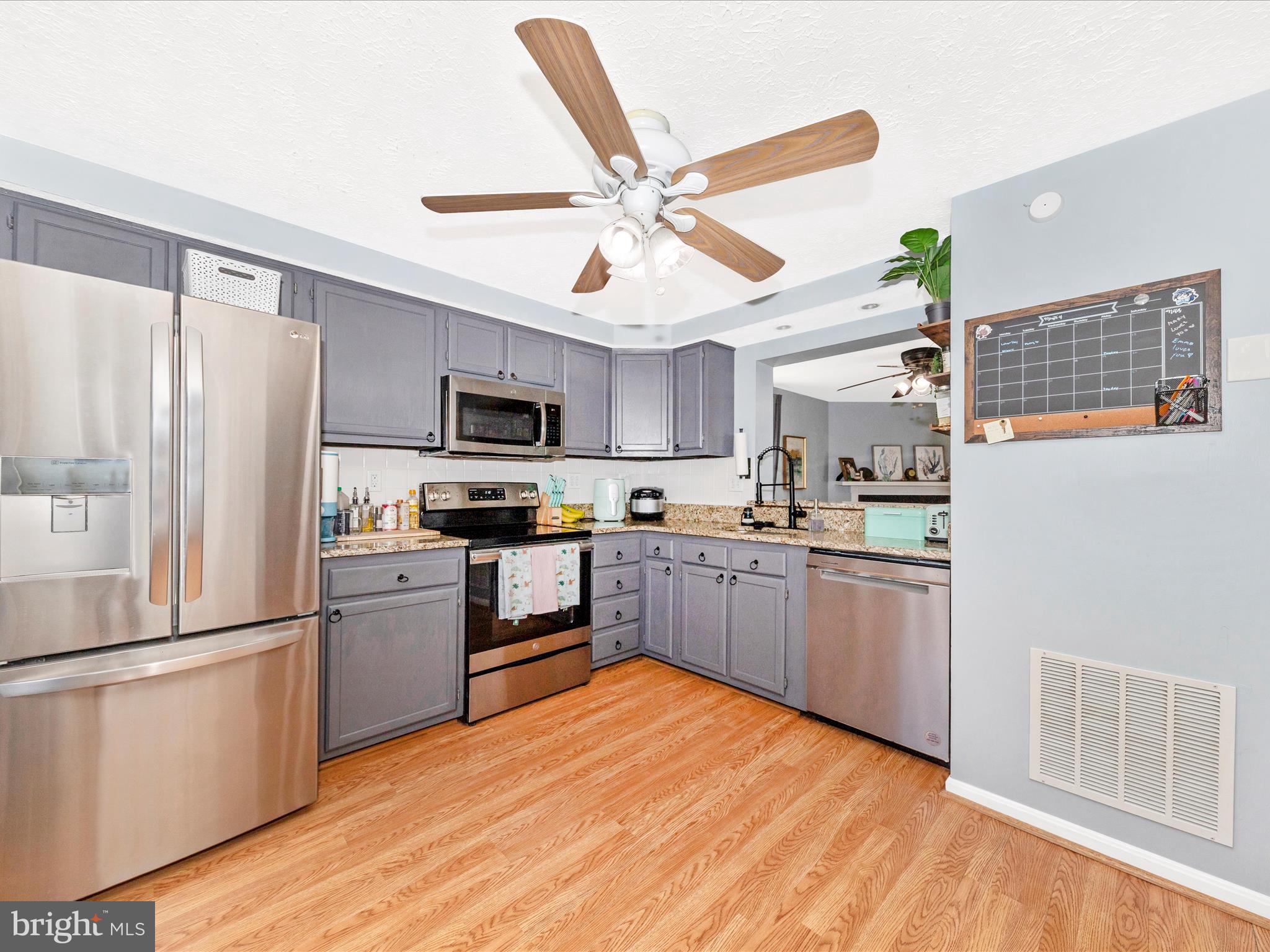 7283 Procopio Circle Columbia, MD 21046 - Photo 8 of 39 a kitchen with stainless steel appliances granite countertop a refrigerator a stove top oven a sink and dishwasher