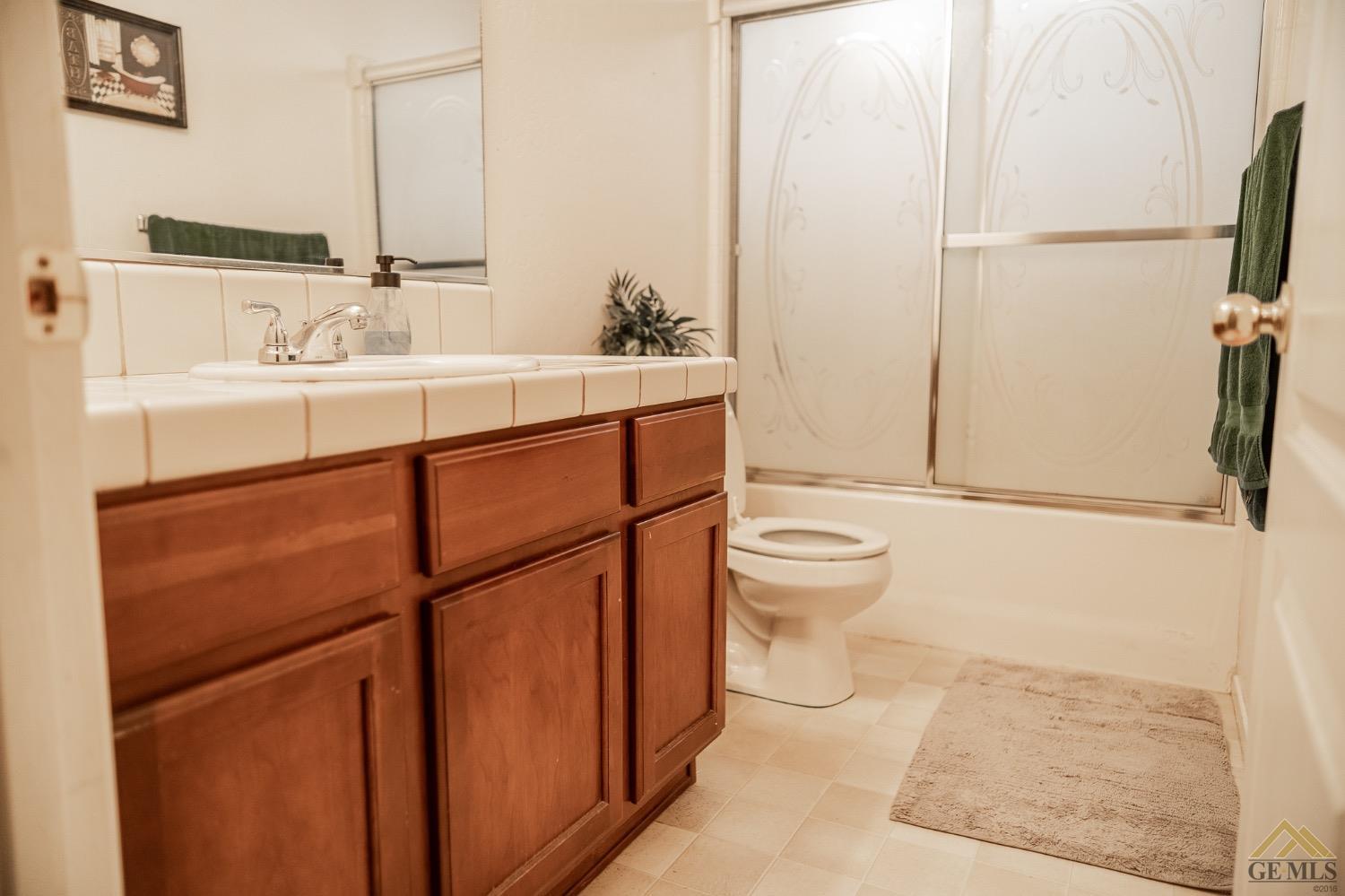 Undisclosed Address Bakersfield, CA 93311 - Photo 16 of 26 a bathroom with a sink a toilet and mirror