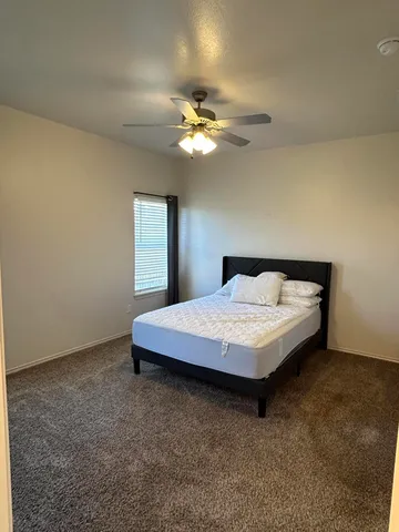 a bedroom with a bed and a chandelier fan