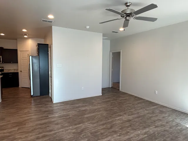 a view of a kitchen with a refrigerator and a wooden floor