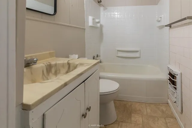 a bathroom with a granite countertop sink a toilet and bathtub