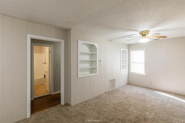 an empty room with windows and closet